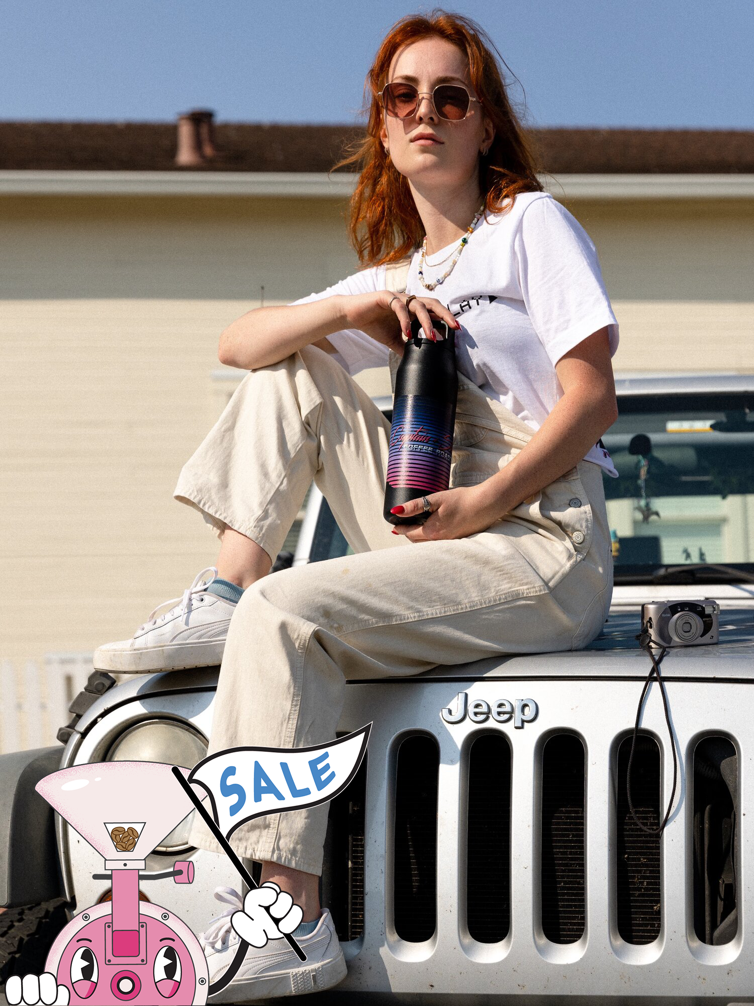 Person holding a 32 oz Miir water bottle sitting on the hood of a Jeep